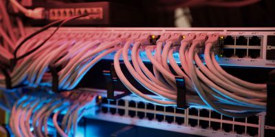 Viele Netzstecker führen in eine Steckerleiste. Leicht rote Beleuchtung .